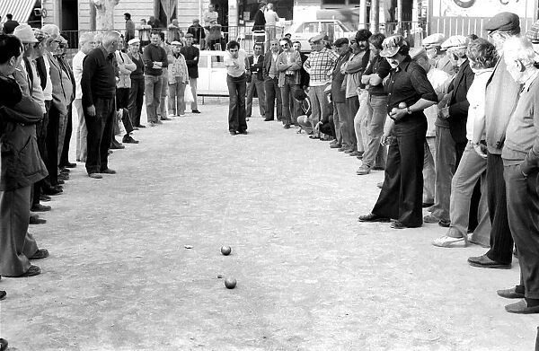Frenchmen play Boules in the streets of Poussan, France. April 1975 75-2097-003