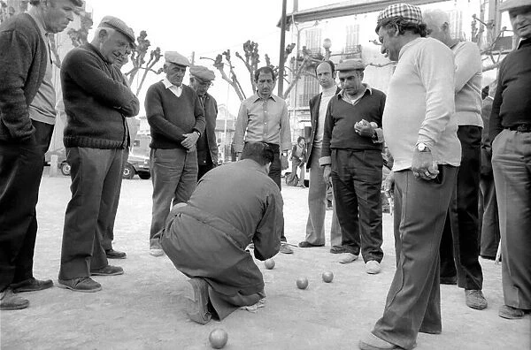 Frenchmen play Boules in the streets of Poussan, France. April 1975 75-2097-008
