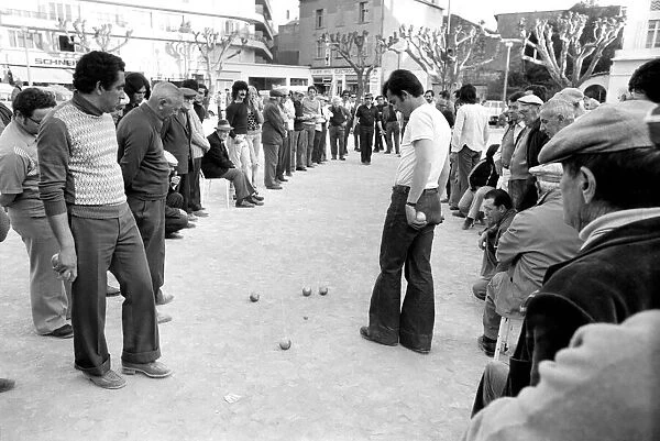 Frenchmen play Boules in the streets of Poussan, France. April 1975 75-2097-006