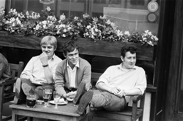 Three friends enjoying a joke and a drink in London. 2nd August 1968