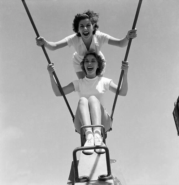 Friends enjoying the swings at a holiday camp. Holiday scenes