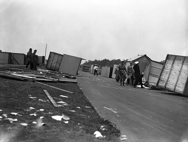 Gale damage. A couple cling desperately to their overturned beach hut at Littlehampton to