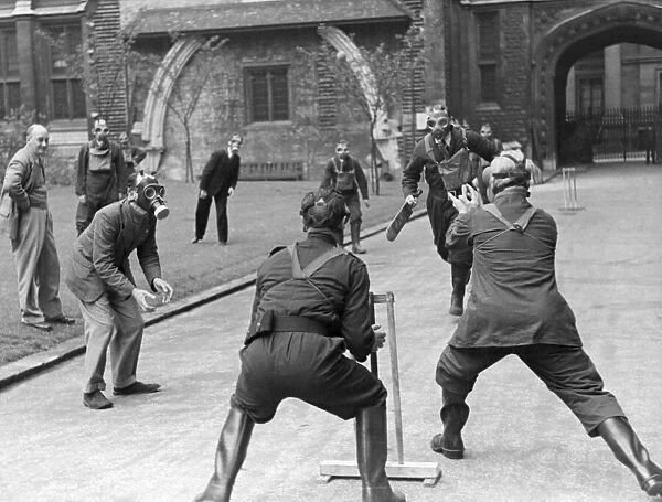 A game of cricket played in an English village by men wearing gas masks May 1941