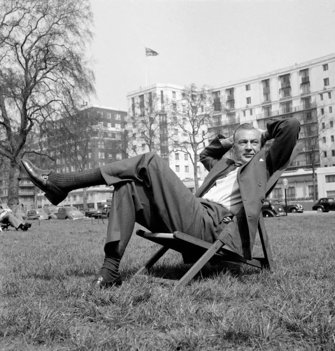 Framed Print : Gary Cooper sitting on a deck chair in London - April 1955 English flag in
