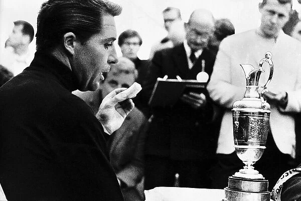 Gary Player eats a banana and contemplates the trophy he has just won at the British Golf
