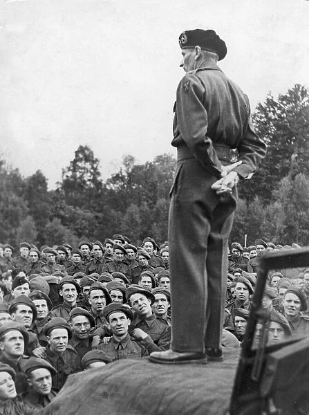 General Bernard Montgomery stands on the bonnet of a jeep as he addresses the troops