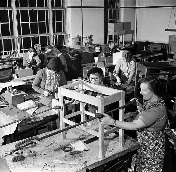 A general view of the woodwork class showing 6 women to one male student at work