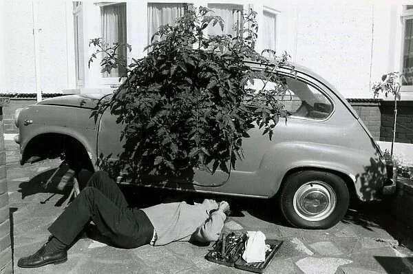 Geoff Poupard tinkers underneath his 'greenhouse car'