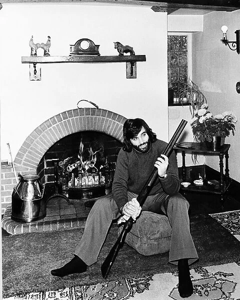 George Best seen here cleaning his gun at home May 1974