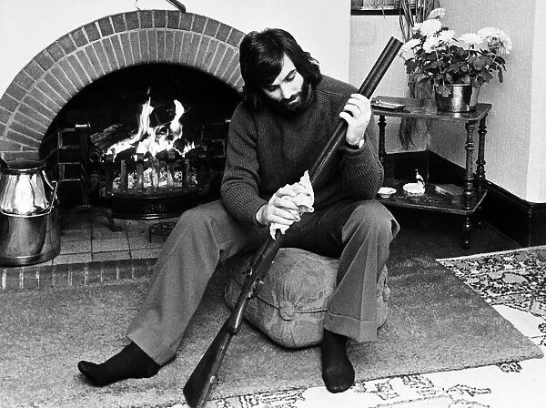 George Best seen here cleaning his gun at home May 1974