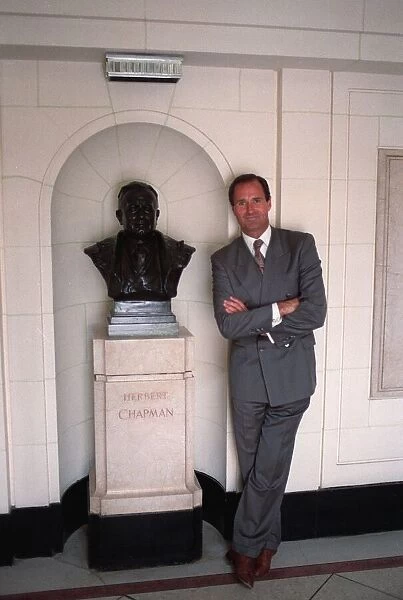 George Graham former Arsenal manager next to a bust of Herbert Chapman in marble hall of
