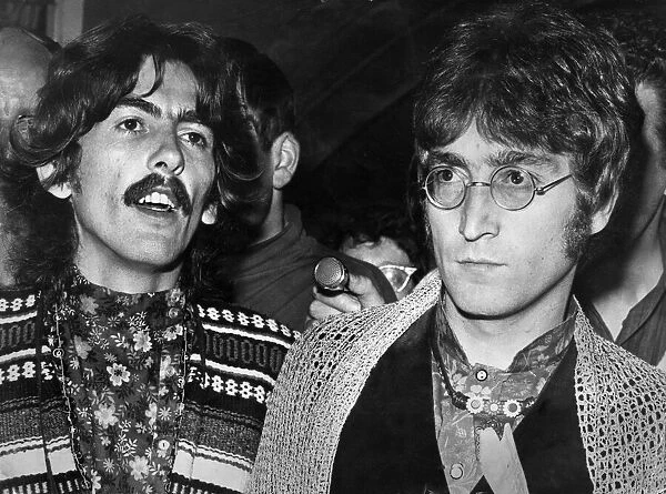 George Harrison and John Lennon of The Beatles talking to the press