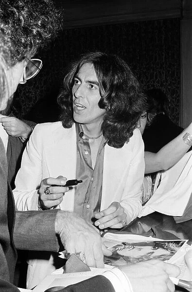 George Harrison signs posters for his new album 'Thirty Three & 1  /  3'