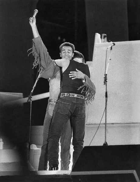 George Michael and Andrew Ridgley (left) of pop duo Wham! on stage for the final embrace