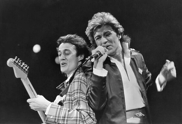 George Michael and Andrew Ridgley (left) of pop duo Wham! performing on stage