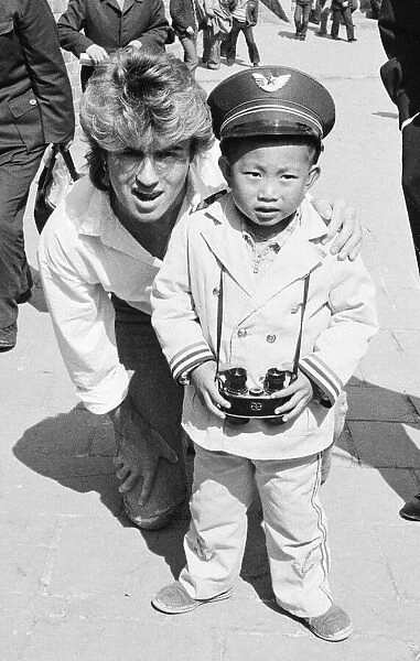 George Michael from Wham ! and a Chinese Boy on The Great Wall of China, in China. 1985