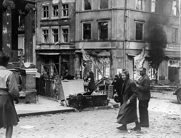German civilians hurry past a burning building in Bamberg