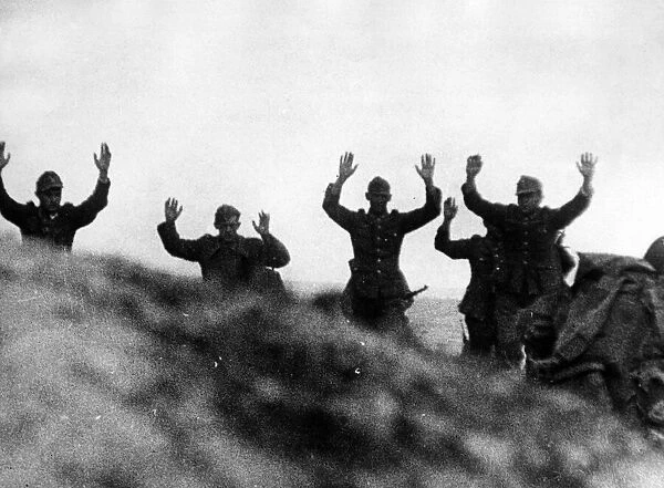 Germans, former 'Herrenvolk', come over the crest of a hill with their hands