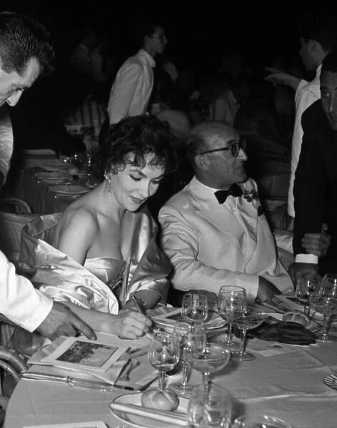 Gina Lollobrigida signs an autograph for a waiter at the Venice Film Festival 1956
