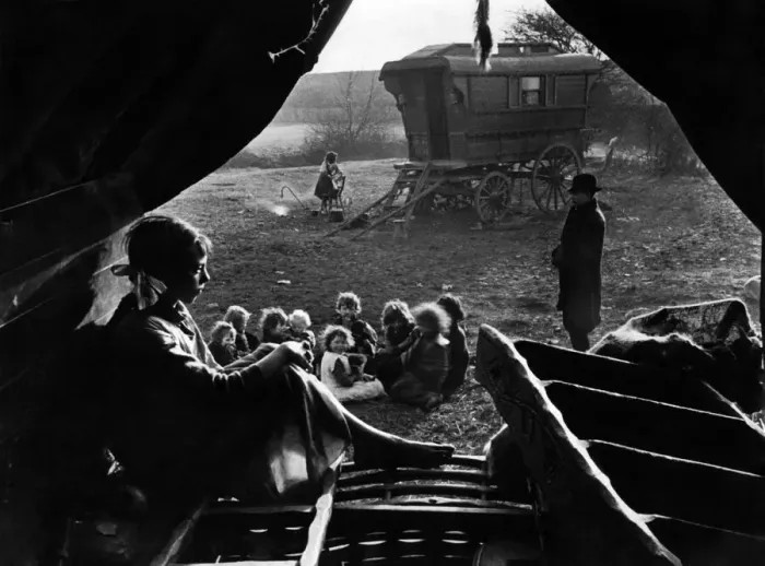 Framed Print : Gipsies in camp. View from inside a tent. A woman sits and thinks while a group of Framed Print : Gipsies in camp. View from inside a tent. A woman sits and thinks while a group of