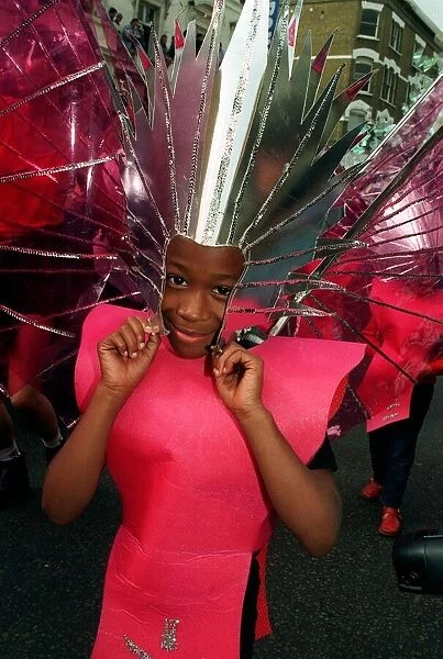 A girl celebrates the Notting Hill carnival in head dress and costume