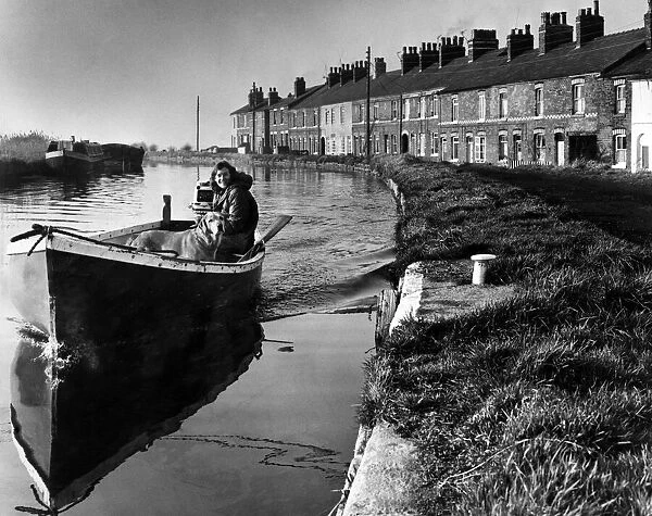 A girl and her dog on a peaceful boat trip on the Leeds and Liverpool canal near Ormskirk