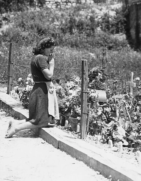 Girl mourns at a mass grave in Gubbio, Italy. 3rd August 1944