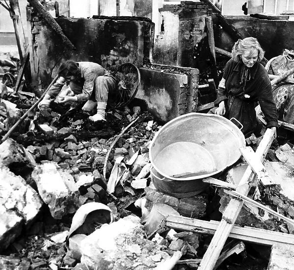 Girl rescue worker searching among the ruins of Eindhoven after another air raid by