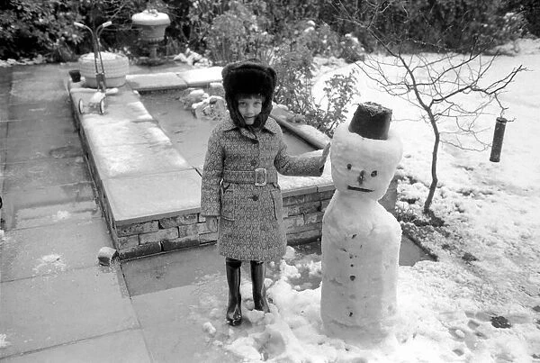 A girl with the snowman she built during the last fall of snow. March 1975 75-1706-011