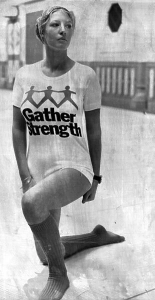 A girl wearing a t-shirt with the slogan 'Gather Strength'written across it