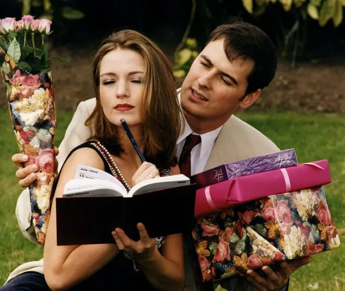 Framed Print : Girl writing in her diary while boyfriend tries to give her presents chocolates Framed Print : Girl writing in her diary while boyfriend tries to give her presents chocolates