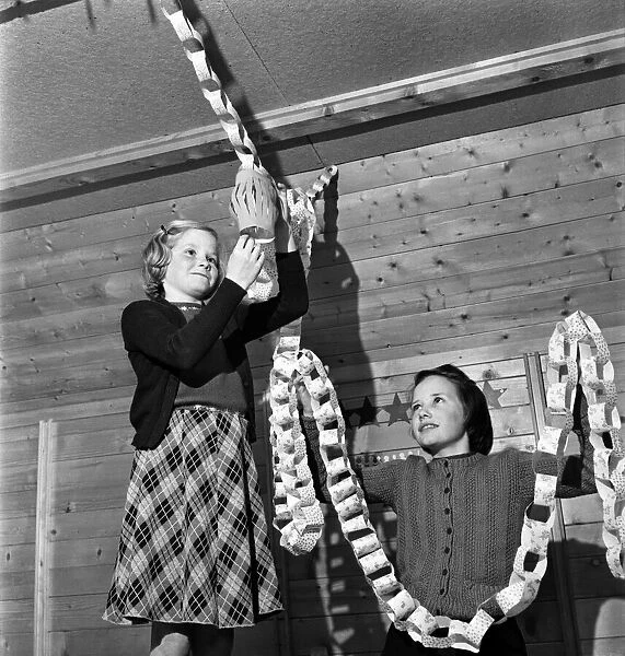 Girls hanging up Christmas decorations in their cabin. Pestalozzi Children