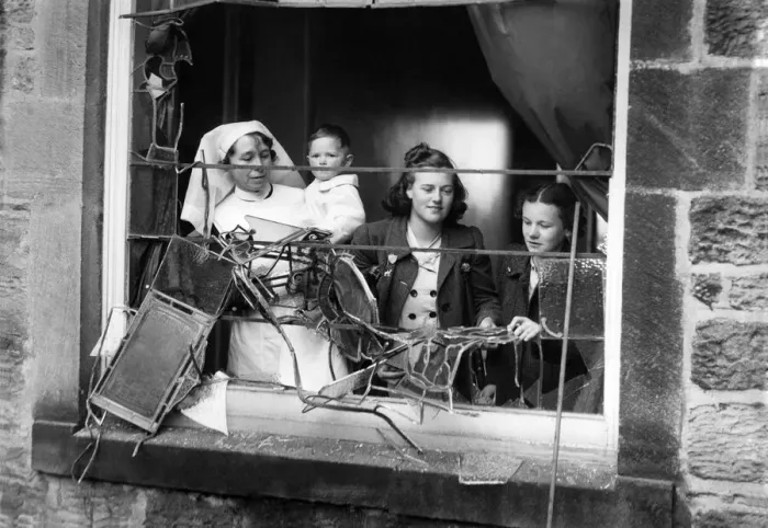 Framed Print : Girls and a nurse holding a litte baby looking out through the smashed window of a bomb Framed Print : Girls and a nurse holding a litte baby looking out through the smashed window of a bomb