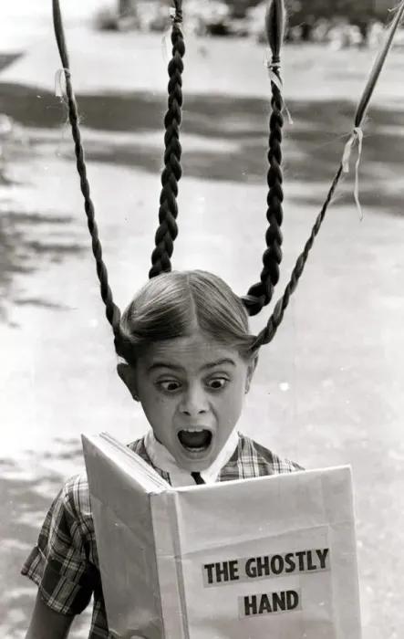 Framed Print : A girls pigtails stand on end in terror as she reads a scary ghost story Framed Print : A girls pigtails stand on end in terror as she reads a scary ghost story