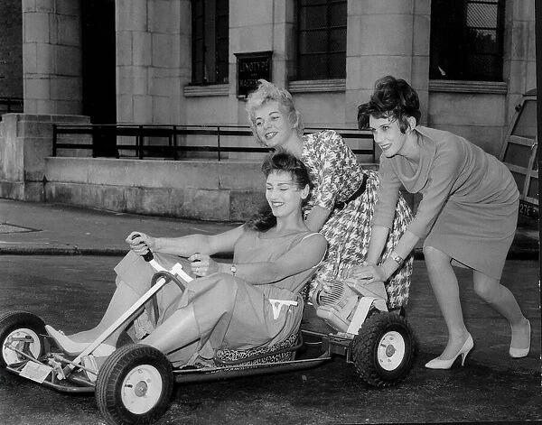 Three girls from the Windmill Theatre in London play around on a go kart, July 1960