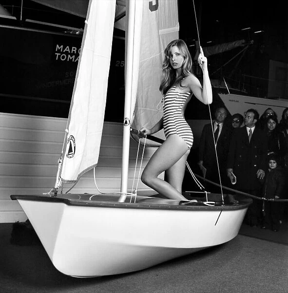 Top glamour model Stephanie McLean posing next to a sailboat January 1975