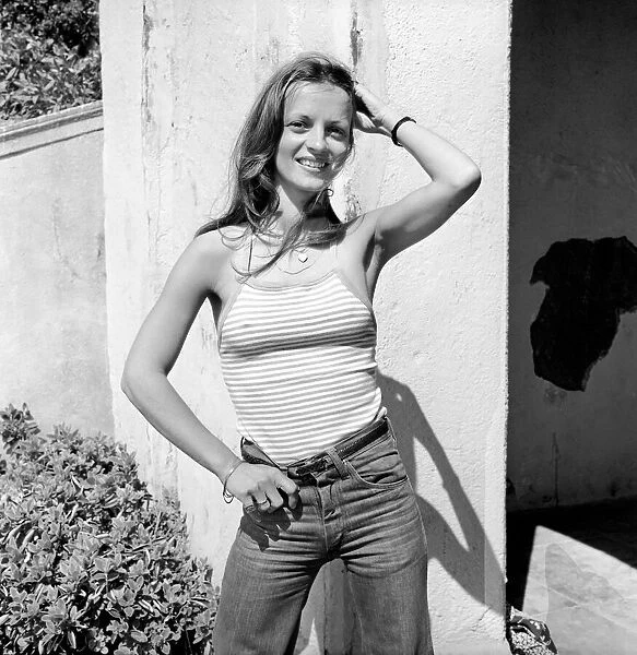 Glamour model wearing a striped vest top and a pair of jeans. April 1975