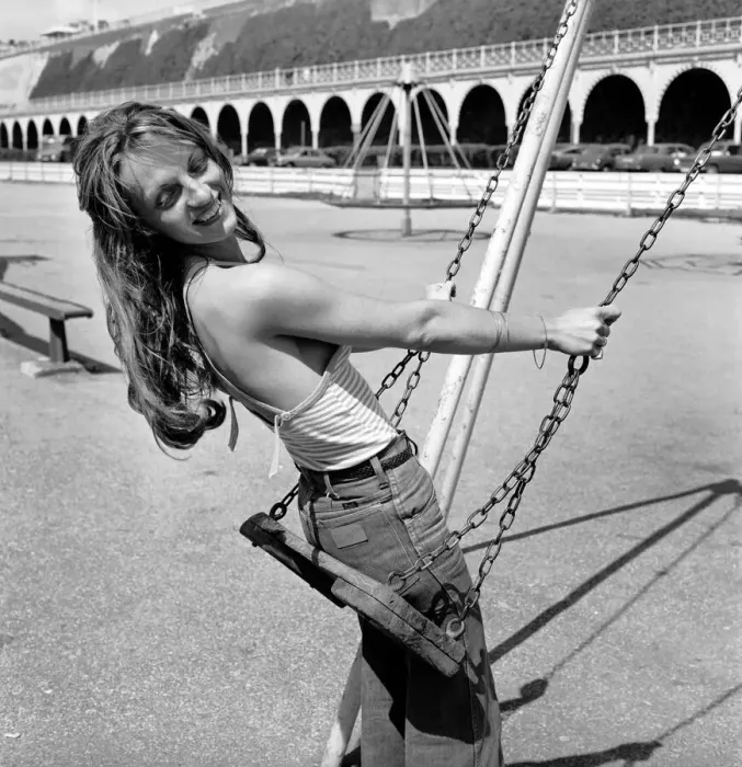 Framed Print : Glamour model wearing a striped vest top and a pair of jeans as she poses on a swing in a Framed Print : Glamour model wearing a striped vest top and a pair of jeans as she poses on a swing in a