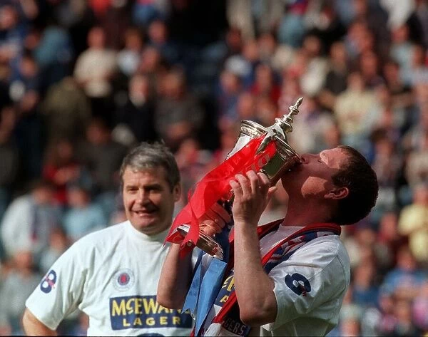 Glasgow Rangers footballer Paul Gascoigne kisses the trophy as he celebrates Rangers win