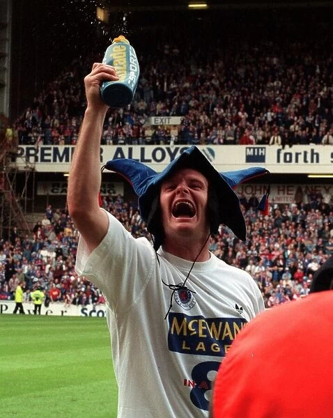 Glasgow Rangers footballer Paul Gascoigne wearing jester hat as he celebrates Rangers win