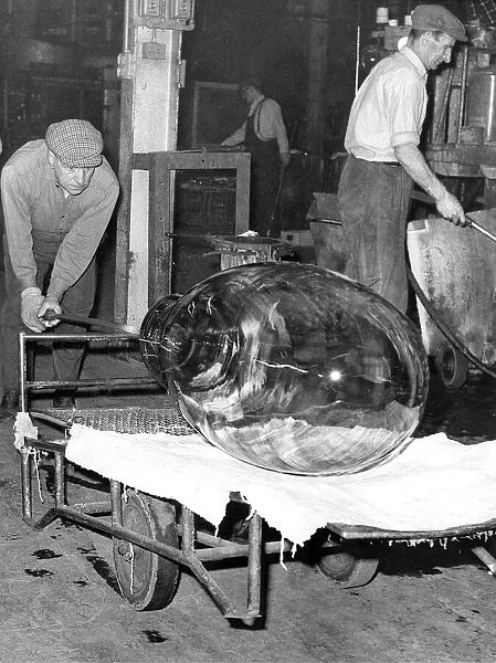 Glass is being taken away to cool after being extracted from the mould in March 1965