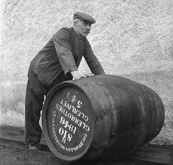 A Glenlivet Distillery worker rolls a barrel of their finest single malt whisky to