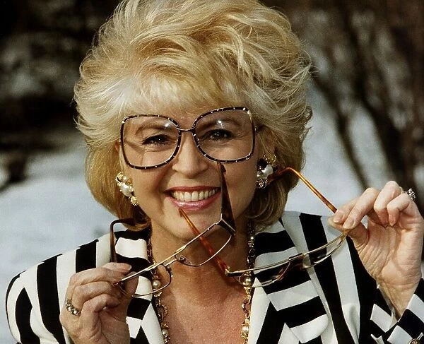 Gloria Hunniford TV Presenter holding glasses in hand voted spectacle wearer of the Year