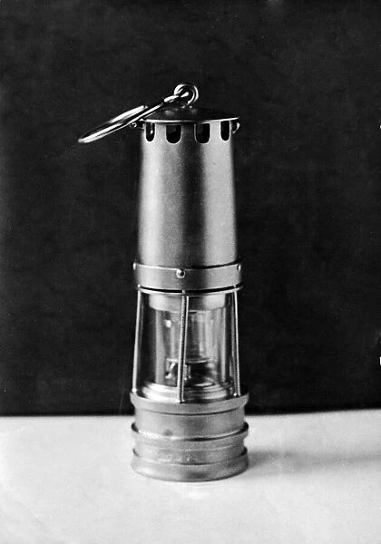 A gold cigar lighter, a replica of a miners safety lamp