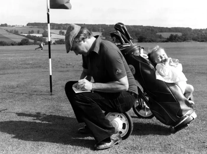 Framed Print : Golf fanatic David Moore who adapted his golf trolley to accomodate his baby daughter Framed Print : Golf fanatic David Moore who adapted his golf trolley to accomodate his baby daughter