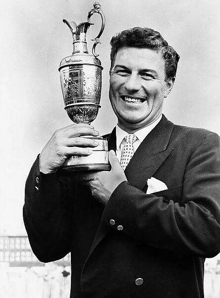 Golfer Peter Thomson holding a trophy wearing a blazer and tie Circa 1955