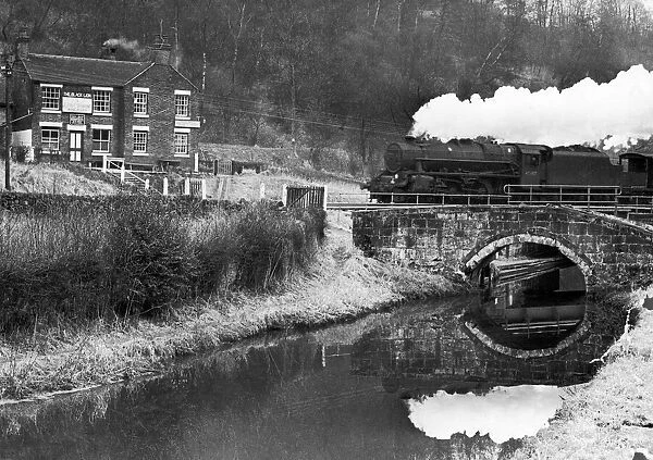 A goods train chuffing past the Black Lion at Consall Forge near Leek, February 1965