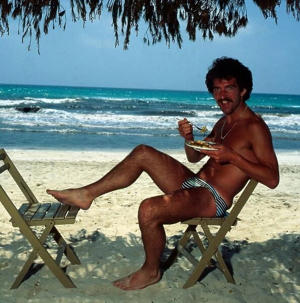 Graeme Souness sitting at the beach in Majorca eating food, 1978