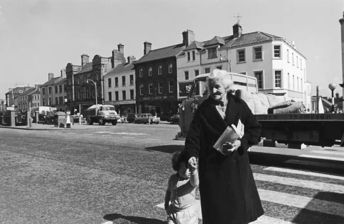 Framed Print : A grandmother and her grandaughter crossing the main road in Lurgan after paying a visit Framed Print : A grandmother and her grandaughter crossing the main road in Lurgan after paying a visit