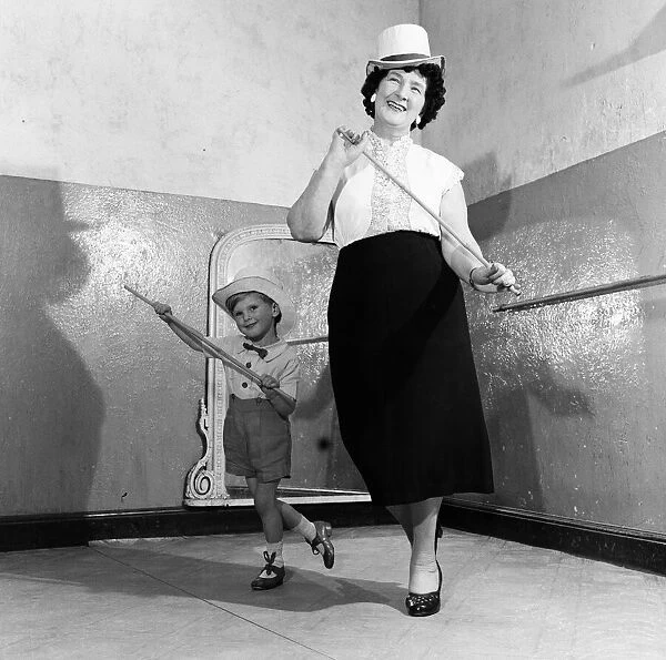 A grandmother teachers her grandson how to dance. 21st June 1955